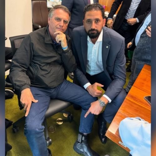 Bolsonaro mostra tornozeleira eletrônica na perna, ao lado de deputado